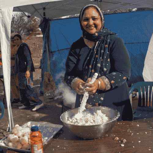 Femeie care pregătește Langar (mâncare gratuită) pentru a servi la traseul paradei Sikh din orașul Yuba