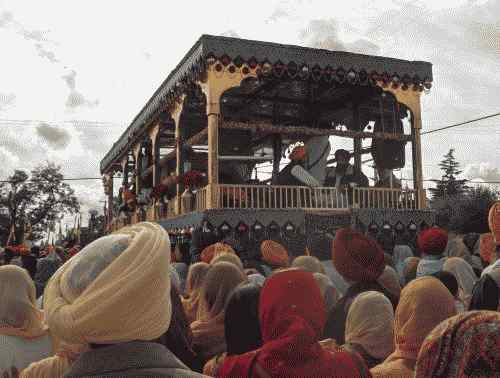 Vedere din spate a plutitorului Guru Gadee care poartă Guru Granth Sahib